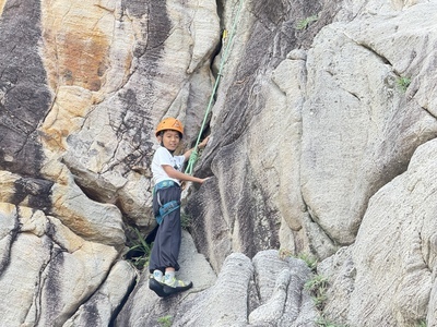 學生在安全裝備與教師引導下挑戰攀岩，練習風險辨識與自我保護。